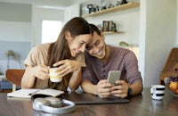 a couple looking at their phone while sitting at a table