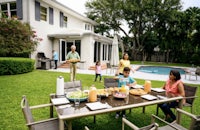 a family is enjoying a meal outdoors in a backyard