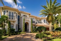 a beautiful home with palm trees in the front yard